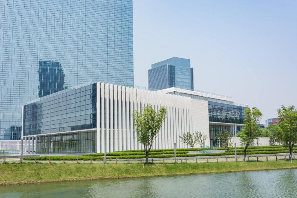 India's affordable, world-class healthcare facilities attract medical tourists in 2024.
Modern healthcare facility with sleek glass architecture surrounded by greenery and a water feature."
